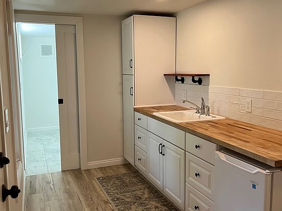 Kitchenette with farm house cast iron sink, lots of cabinet space, Butcher block counters, Mini fridge and pantry.