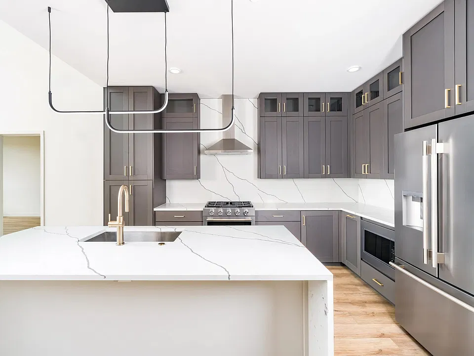 Chef-inspired kitchens feature quartz waterfall islands, full-height cabinetry, stainless steel appliances, and designer lighting that elevate both everyday cooking and entertaining.