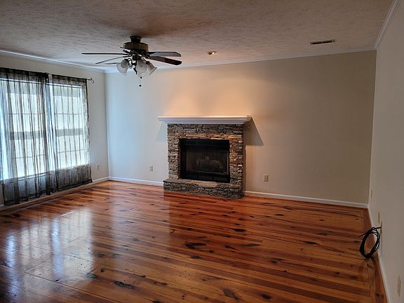 Living area features heart pine flooring and dry stacked stone fireplace.