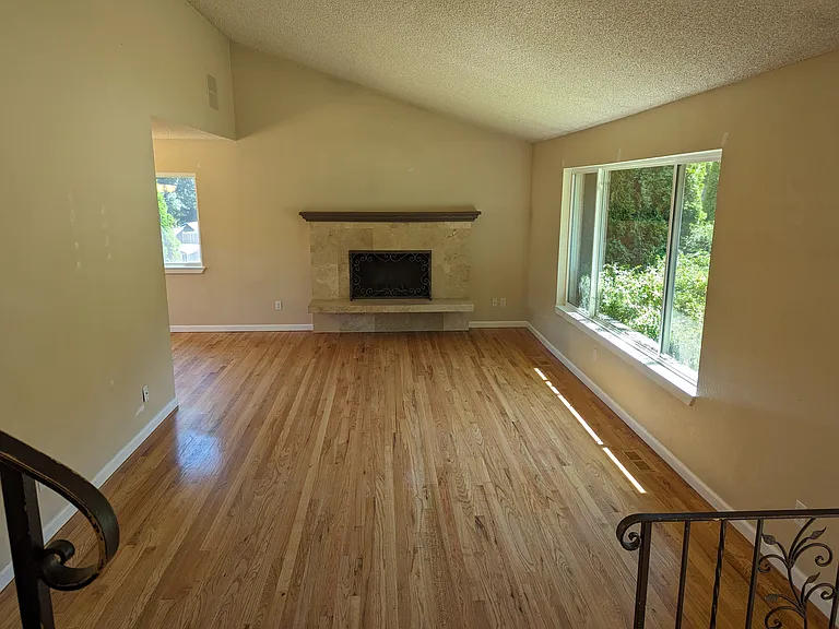 Living room with vaulted ceiling and wood burning fireplace