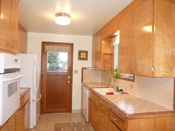 Awesome period kitchen with updated white GE appliances. Nice large Galley kitchen with access to hu