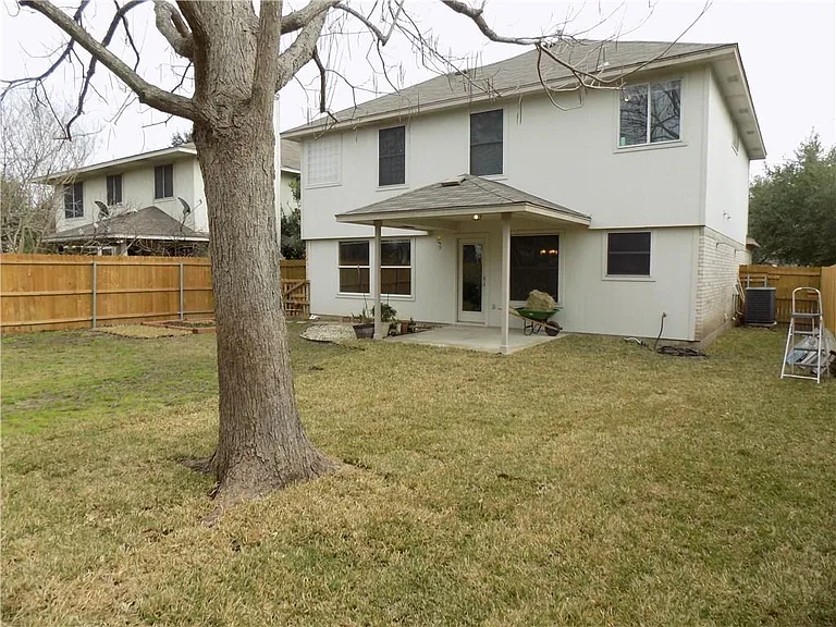 Fenced in backyard with covered patio