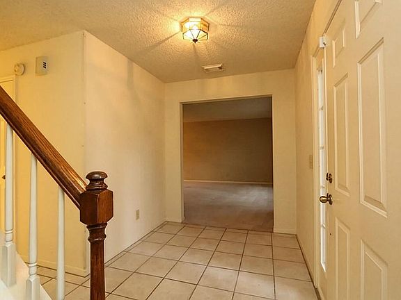 The entry way has tile flooring with a living area & the formal dining room just to the right.