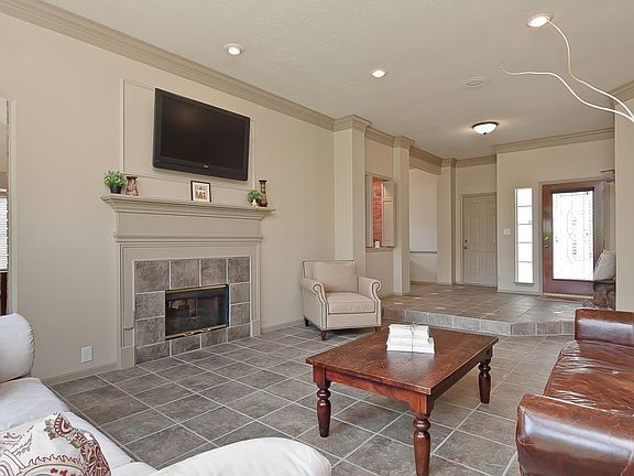 The living room has a dual-sided fireplace with gas logs, wood mantel, ceramic tile surround and hea