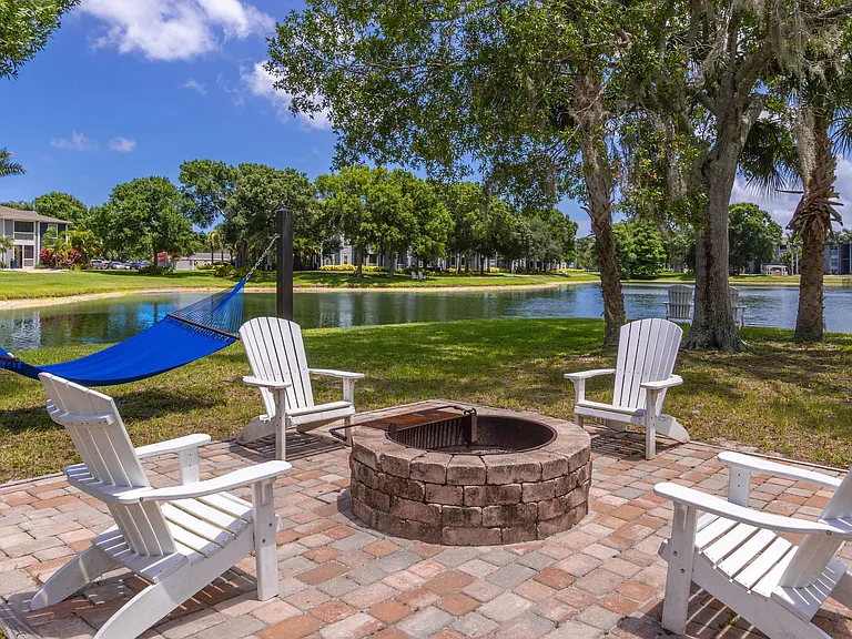 Unwind with friends by the fire pit or sway in the hammock while enjoying the serene lake views at Grand Oaks Apartments.