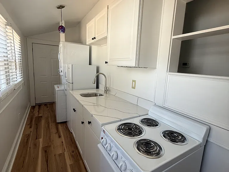 Unit A - Kitchen with new appliances including oven/stove, sink, refrigerator, washer/dryer