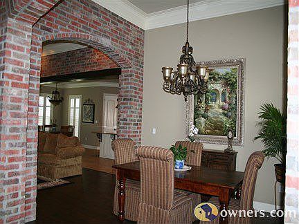 Open formal dining and living area with exposed brick archways
