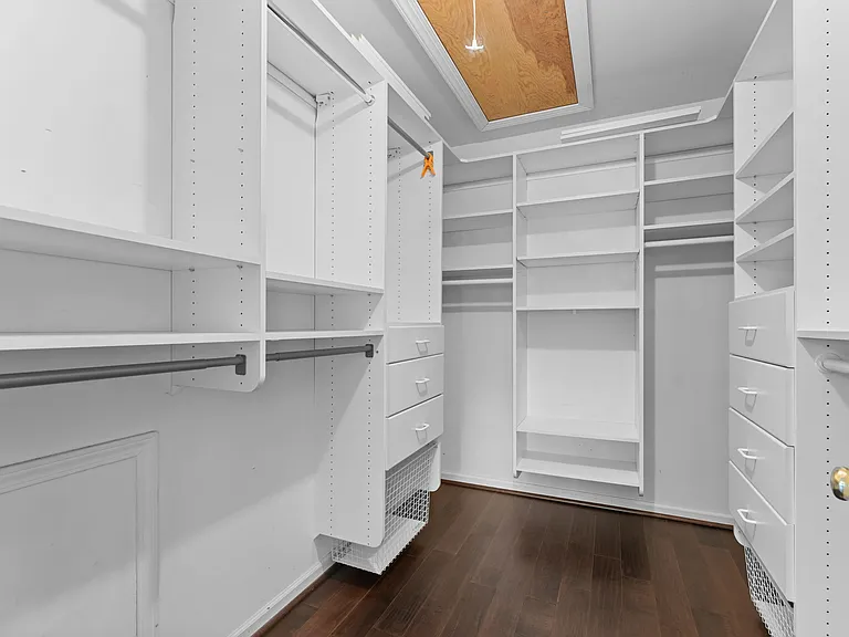 primary bedroom walk in closet with custom closet organizer