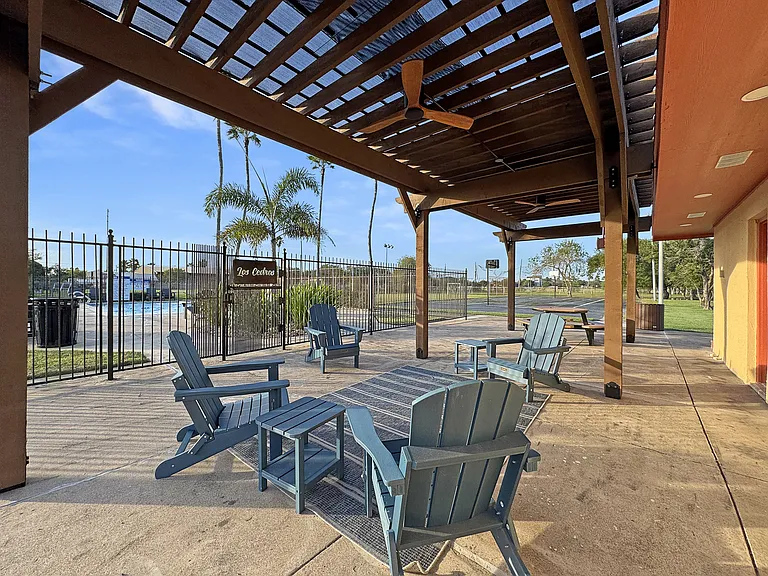 Relaxing outdoor lounge area under pergola at Los Cedros Apartments in Brownsville, TX.