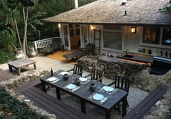 Outdoor patio has outdoor dinning, sitting lounge and a bar counter with gas grill