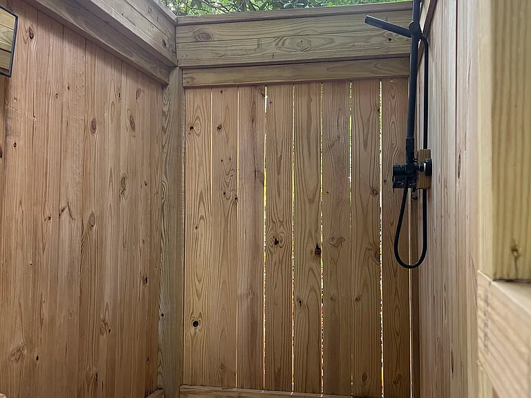 Outdoor shower beneath magnolia