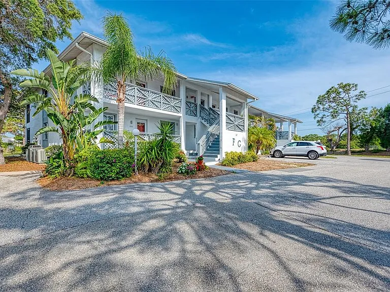 Lush views from every angle. __ Whether you're coming or going, you're surrounded by beautiful Florida greenery. Our building is tucked away among palm trees & tropical blooms, making every stroll feel like a walk through a botanical garden.