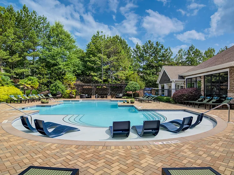 Resort-style saltwater swimming pool with lounge chairs and sundeck at Waterstone at Big Creek apartments for rent