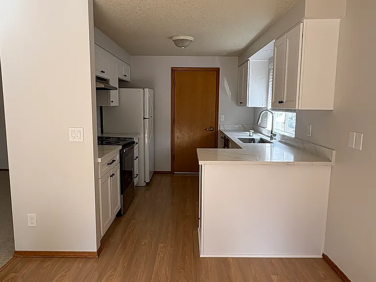 Efficient kitchen - all new cabinets, quartz countertops, sink/faucet and dishwasher. Door leads to the two car garage