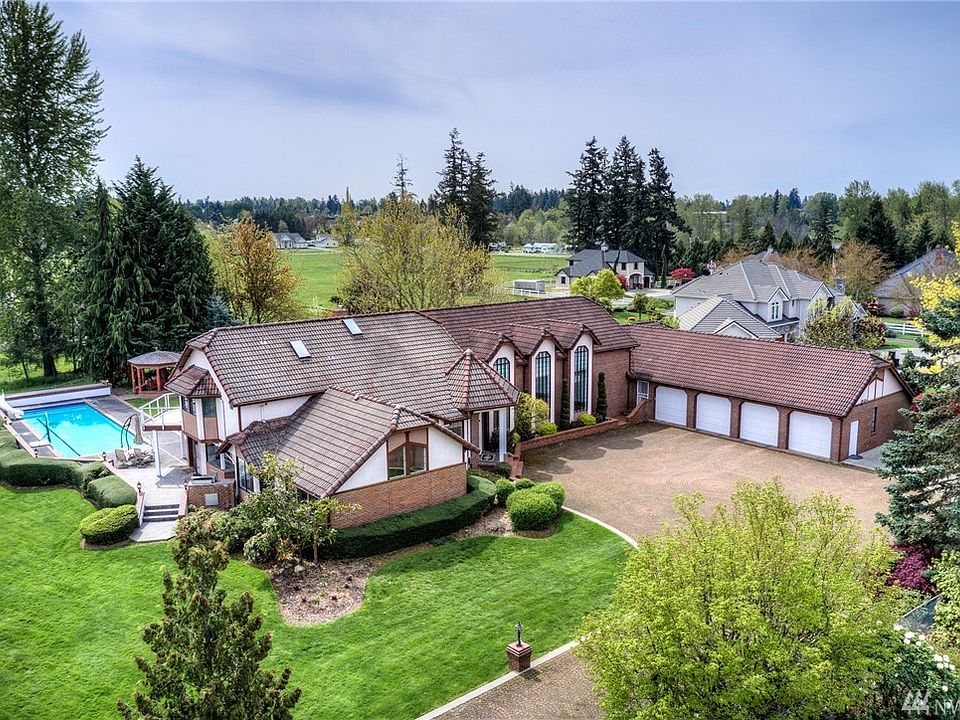 Luxury equestrian estate with beautiful architectural styling. Classic brick and stucco façade with tile roof is timeless and elegant.