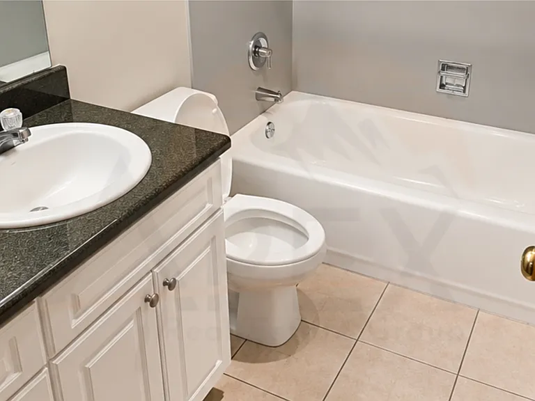 Bathroom features a white vanity, dark countertop, full tub, and practical layout for everyday use.