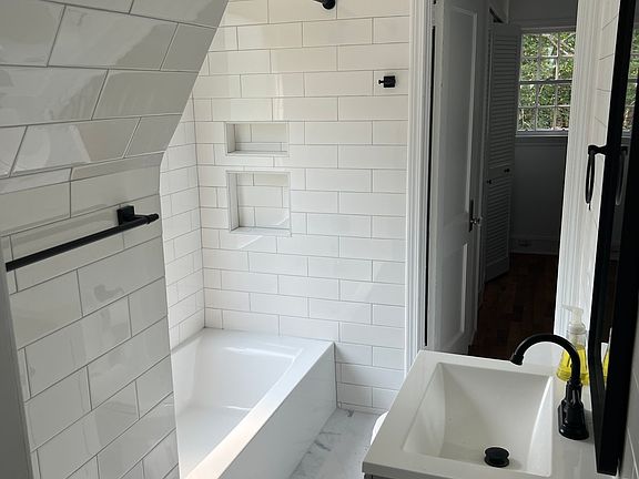 Brand new bathroom with full ceramic subway tile and shower/tub combo.