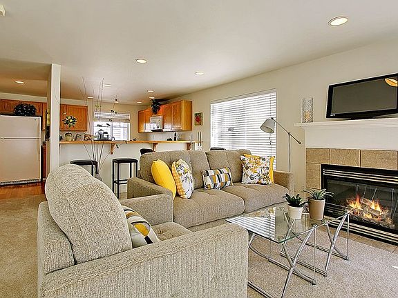 Spacious living room with new carpets, gas fireplace, recessed lighting enjoys great western exposures and light.