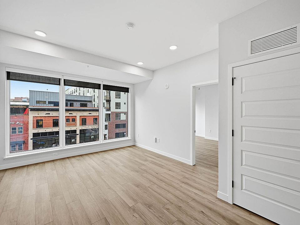 Large bedroom with large windows featuring city views