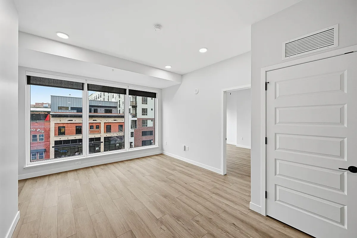 Large bedroom with large windows featuring city views - AMLI Golden Triangle