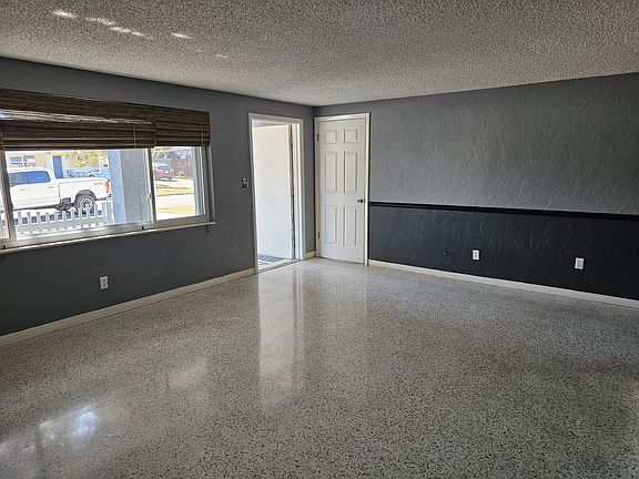 This large living room greets guests and leads to the kitchen, dining room, and another huge family room with lots of windows and a third bedroom that leads to the large back yard.