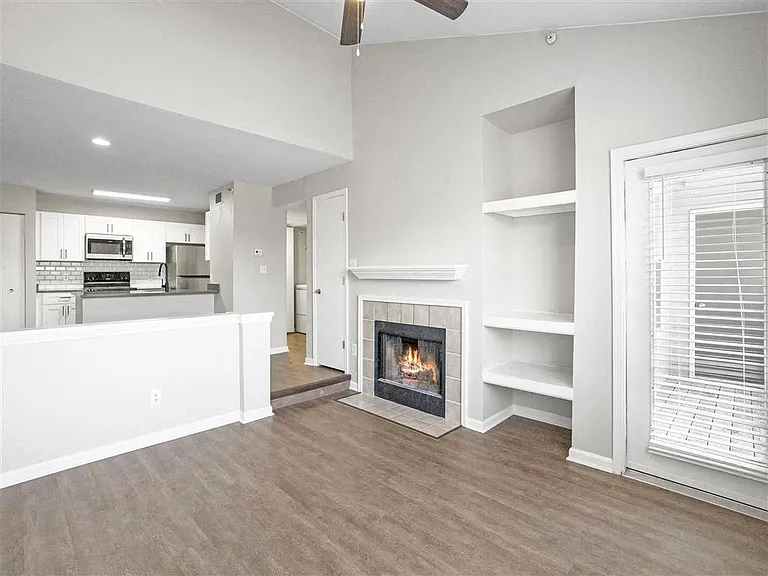 Gorgeous open concept living area with a fireplace and ceiling fan at The Crossings at Russett in Laurel, MD
