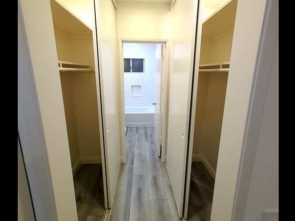 large hall way that leads to the bathroom with a large closet space