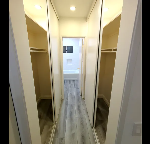 large hall way that leads to the bathroom with a large closet space
