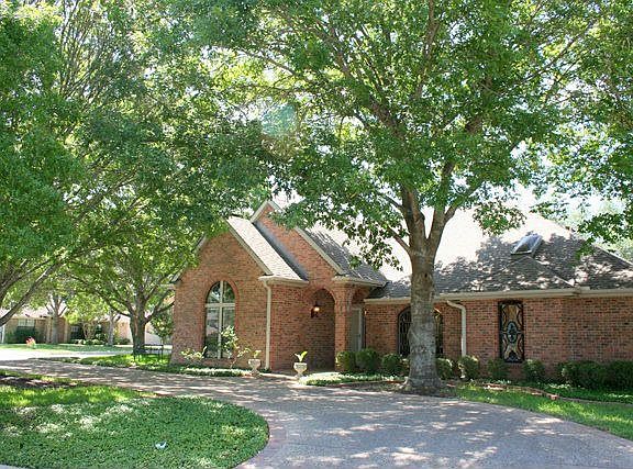 Beautiful large oaks surround this lovely brick home.