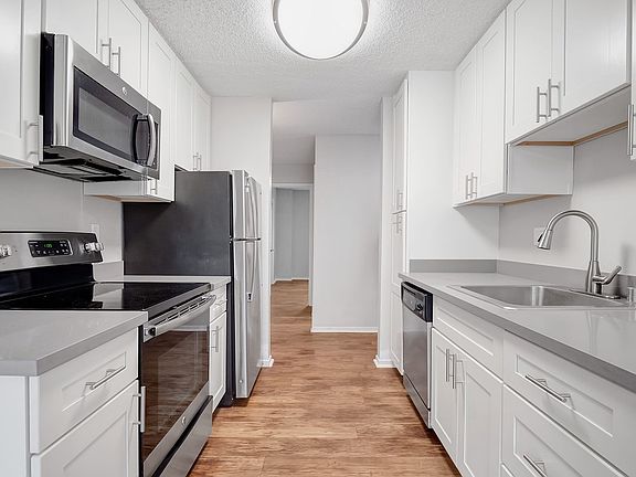 Kitchens feature stainless steel appliances and wood flooring