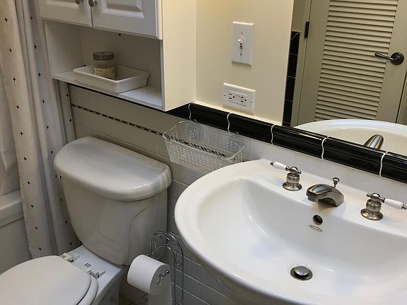 Mirror contains concealed shelving for toiletries storage.