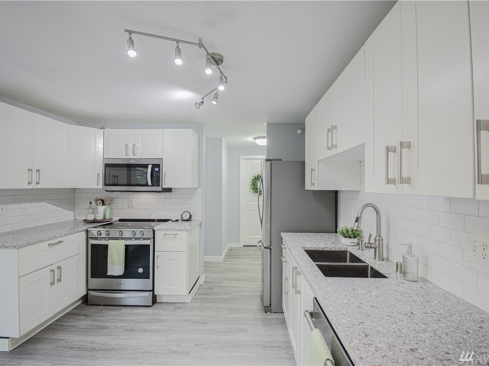 clean and bright remodeled kitchen with new cabinets, quartz countertops and white subway tile backsplash 
