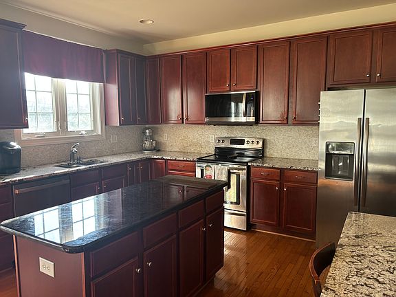 Renovated with stainless steel appliances and granite counter tops with textured white backsplash