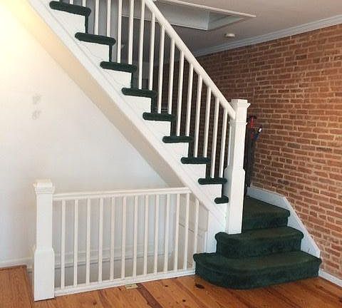 Living room with wide board floors and exposed brick