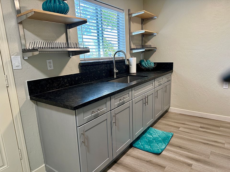 New cabinetry and stainless steel bamboo upper shelving, with dish racks on both right and.