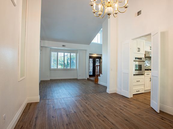 Living & Dining: Bright and open, the formal living and dining area boasts large windows with plantation shutters, perfect for entertaining or family gatherings in a spacious and sunlit setting.