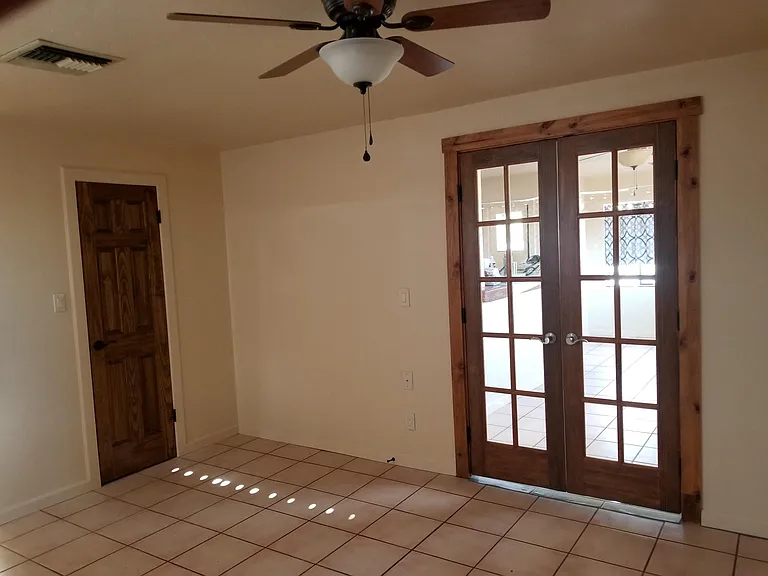 Second bedroom, living room, or large office. Wooden French doors to the rest of the house.