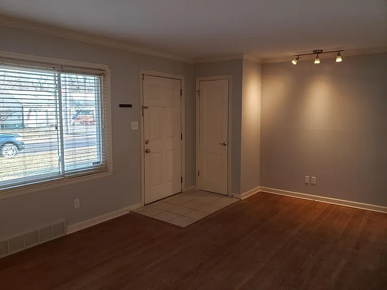 Entryway tiled with coat closet. Hardwood floors in the large living room extends into the hall and both bedrooms.