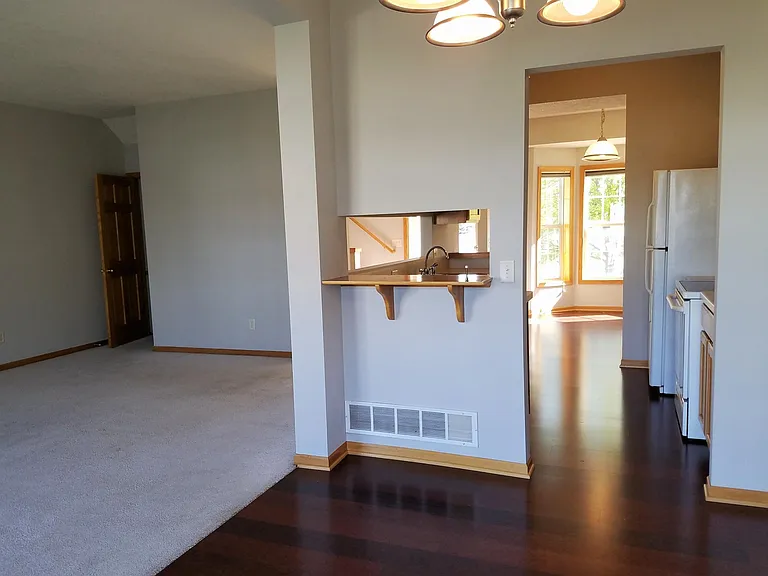 Living room with door to basement, kitchen pass through