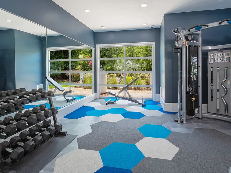 Elevate your wellness routine in our modern fitness center, featuring strength training equipment, free weights, and energizing natural light.