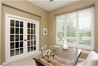 The study features pocket french doors, plantation shutters and window seat.