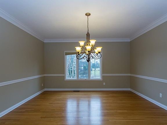 Formal dining room with crown molding, hardwood floors and chair rail.