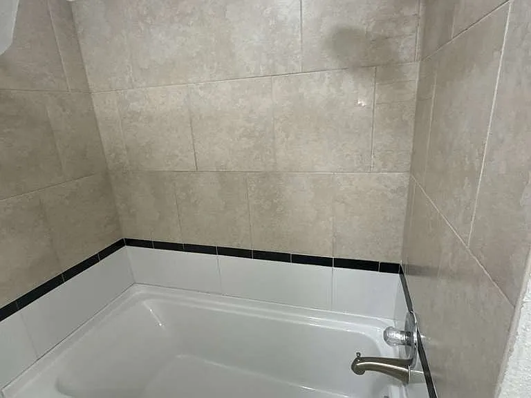 Tiled bathroom shower, spotless and well-kept for the next tenant.