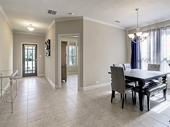 The foyer welcomes guests with crown moulding and ample wall space to hang art and place furniture. Immediately upon entering, you'll notice the natural light spilling in from the rest of the house.