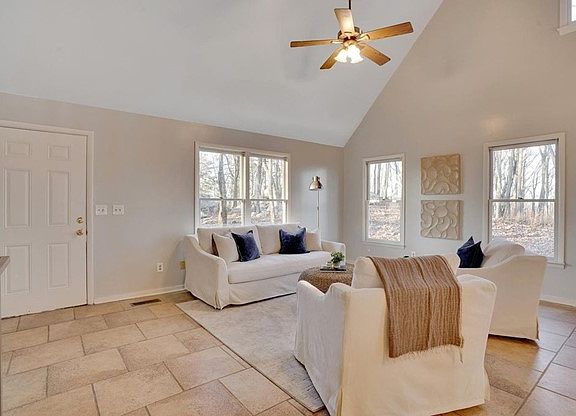 Living area of great room seen from behind kitchen bar. Area looks out to outstanding rock formations and forest.