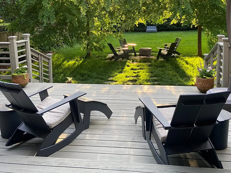 Back deck with view of fenced-in yard, and Room & Board furniture