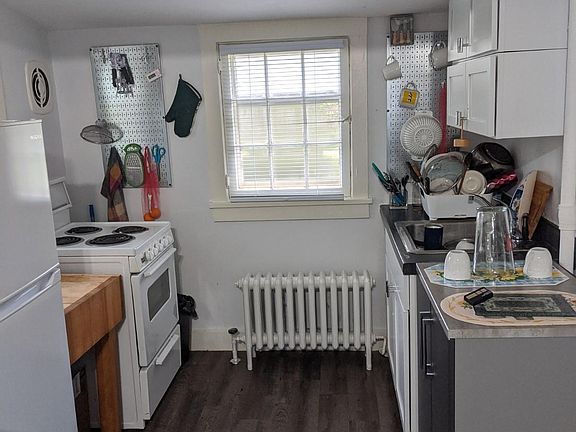Stainless steel hanging racks on wall remain in the kitchen. New flooring throughout.