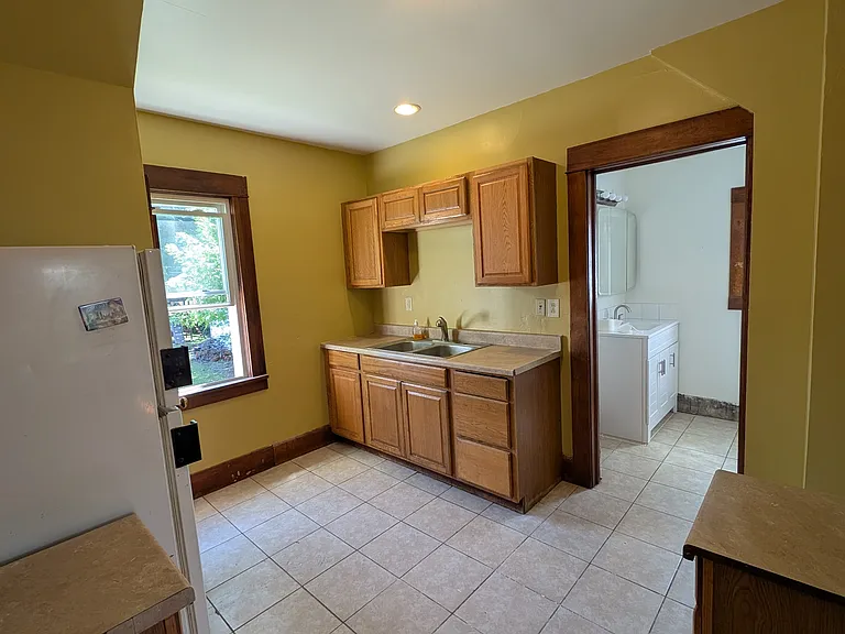 Kitchen with fridge and over the range microwave.