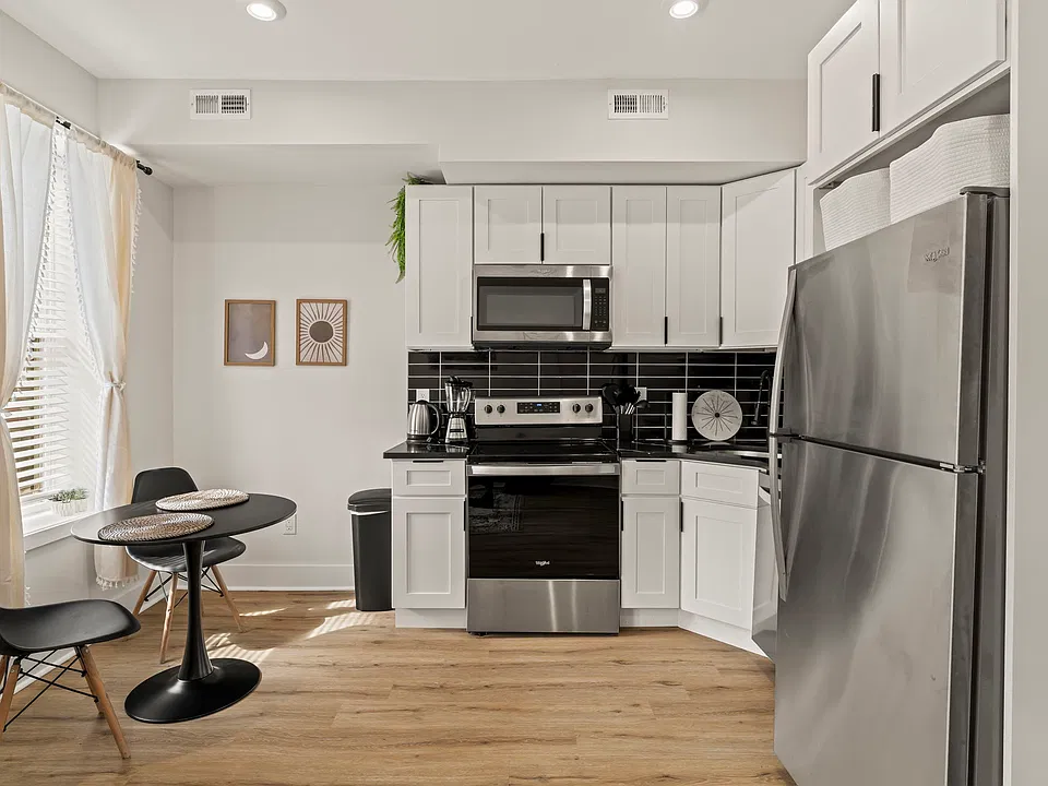 Cook real meals in a full kitchen with stainless appliances and crisp white cabinetry, then enjoy them at your bistro table for two by the window.