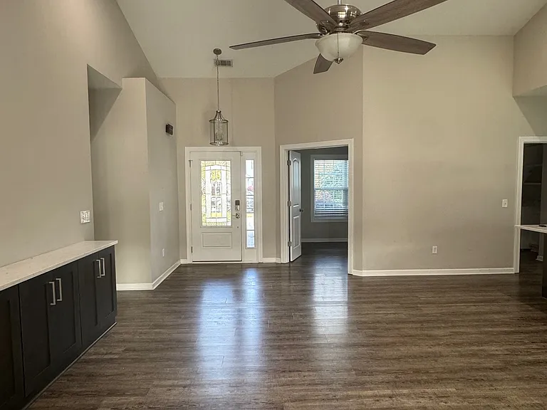 standing at back sliding glass door looking through living room at front door, office door and laundry/hallway to garage.
Master bedroom hall to the left.